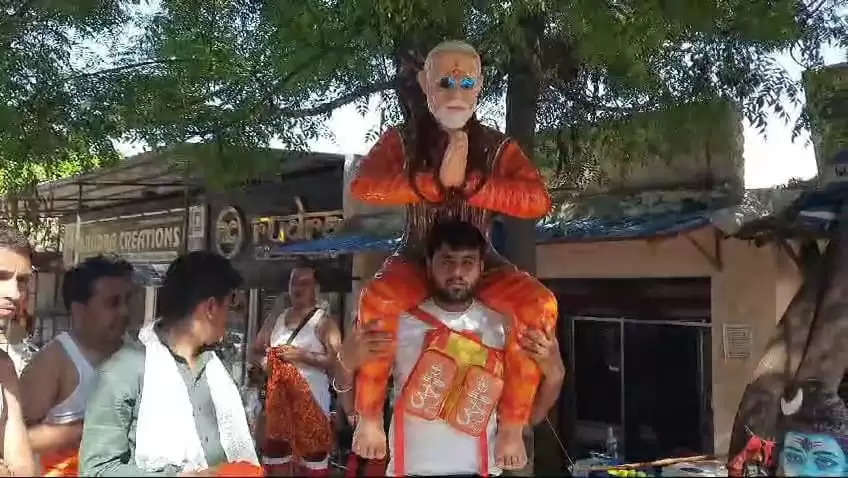 कांवड़ियों का अलग अंदाज: एक के कंधे पर भगवान शिव और दूसरे के कंधे पर प्रधानमंत्री मोदी की मूर्ति