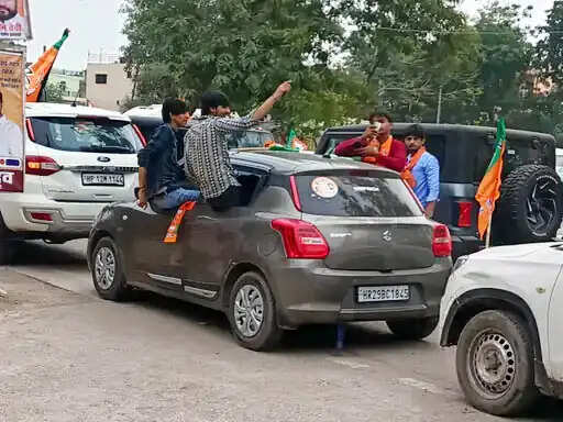 फरीदाबाद : रोड शो में टूटे यातायात नियम, कार की खिड़कियों पर बैठ मांगे वोट