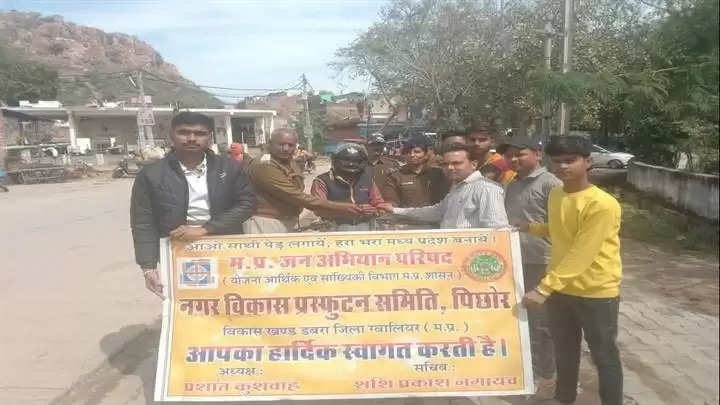 ग्वालियरः हेलमेट पहने दुपहिया वाहन चालकों को मिठाई खिलाकर भेंट किए गुलाब के फूल