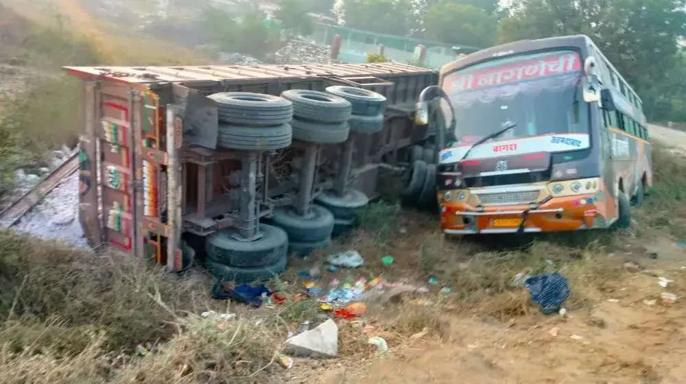 सवारियों से भरी बस को टक्कर मारकर ट्रक गड्ढे में पलटा, बस में सवार तीन यात्री घायल