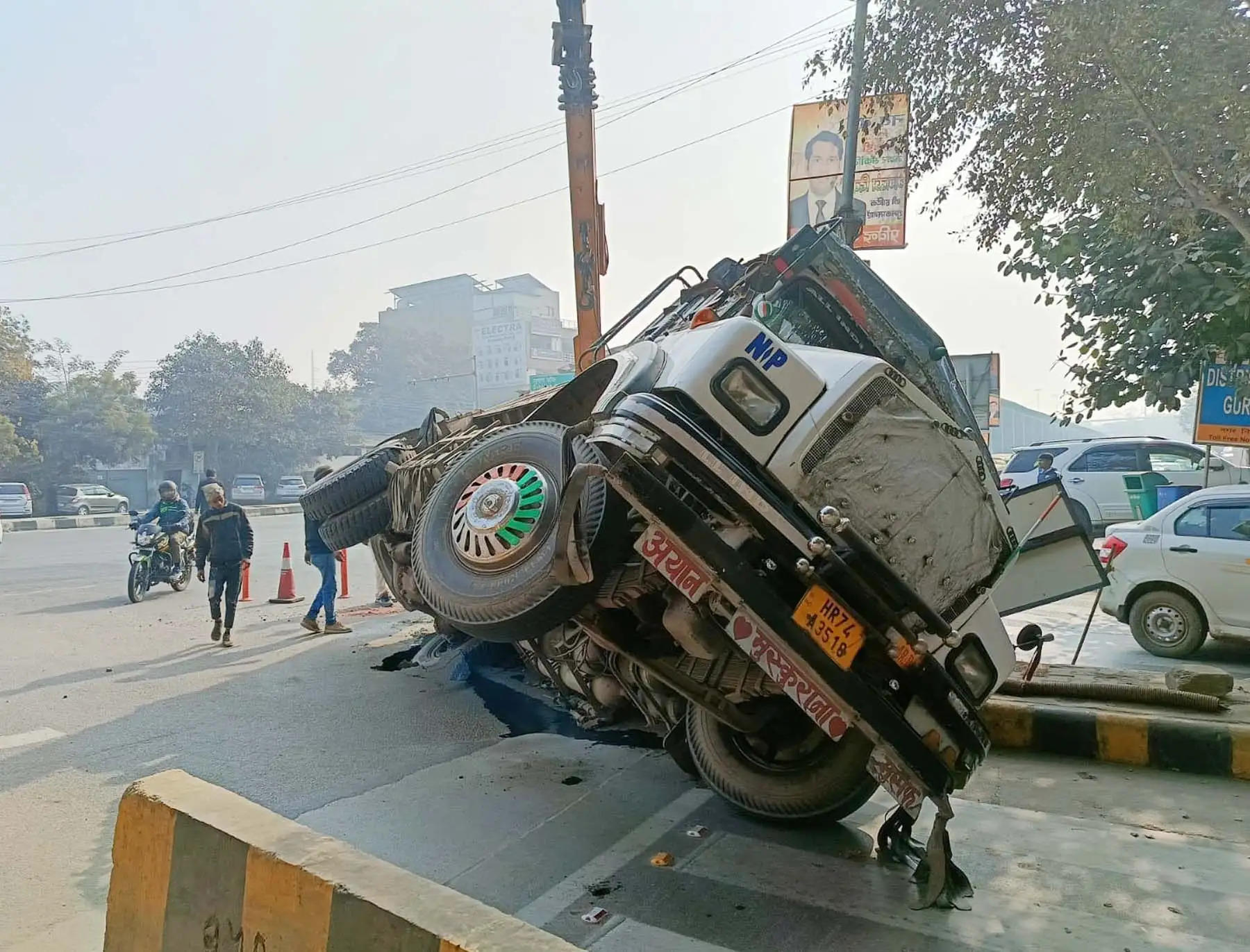 गुरुग्राम: कोर्ट के बाहर धंसी सडक़ में रेती से भरा ट्रक फंसा