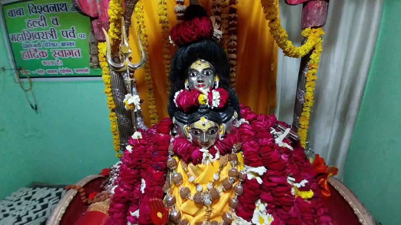 वाराणसी। ‘पहिरे ला मुंडन क माला मगर दुल्हा लजाला..’,‘दुल्हा के देहीं से भस्मी छोड़ावा सखी हरदी लगावा ना...’, 'शिव दुल्हा के माथे पर सोहे चनरमा...।’ काशी विश्वनाथ मंदिर के पूर्व महंत आवास सोमवार को लोकगीतों से गुंजायमान हो उठा। अवसर था भूतभावन भगवान शिव के विवाह से पूर्व हल्दी के लोकाचार का। महाशिवरात्रि पर बाबा विश्वनाथ से जुड़ी लोकपरंपरा का निर्वाह इस वर्ष श्रीपंचायती निरंजनी अखाड़ा के नागा साधुओं एवं महात्माओं की ओर से किया गया। श्रीपंचायती निरंजनी अखाड़ा की ओर से बाबा के लिए हल्दी महाराणा प्रताप की धरती मेवाड़ से मंगाई गई।  श्रीपंचायती निरंजनी अखाड़ा की उदयपुर शाखा के प्रभारी संत दिगंबर खुशहाल भारती के नेतृत्व में नागा साधुओं एवं संन्यासियों का समूह मणिकर्णिका तीर्थ से शोभायात्रा के रूप में टेढ़ीनीम स्थित महंत आवास के लिए प्रस्थान किया। डमरुओं की गर्जना और हरहर महादेव के घोष के साथ साधु-संतों और गृहस्थ भक्तों का समूह महंत आवास पहुंचा।  एक थाल में हल्दी, 11 थाल में फल, पांच थाल में मेवा-मिठाई, एक थाल में वस्त्र और एक थाल में आभूषण लेकर वे महंत आवास पहुंचे। यहां परंपरागत ढंग से सभी का स्वागत किया गया। संत दिगंबर शुखहाल भारती ने बाबा के लिए मेवाड़ से मंगाई गई हल्दी की थाल, जिसका पूजन प्रयागराज में किया गया था, बाबा को अर्पित की। महंत परिवार के सदस्यों ने सभी साधु-महात्माओं को अंगवस्त्रम् एवं रुद्राक्ष की माला भेंट कर उनका स्वागत किया। इसके बाद महिलाओं ने हल्दी की रस्म पूरी की। एक तरफ मंगल गीतों का गान हो रहा था दूसरी तरफ बाबा को हल्दी लगाई जा रही थी। मांगलिक गीतों से महंत आवास गुंजायमान हो रहा था। ढोलक की थाप और मंजीरे की खनक के बीच शिव-पार्वती के मंगल दाम्पत्य की कामना पर आधारित गीत गाए गए।  ‘अड़भंगी क चोला उतार शिव दुल्हा बना जिम्मेदार’, और ‘भोले के हरदी लगावा देहिया सुंदर बनावा सखी...’आदि हल्दी के  गीतों में दुल्हे की खूबियों का बखान किया गया तो दूल्हन का ख्याल रखने की ताकीद भी की गई।  मंगल गीतों में यह चर्चा भी की गई कि विवाह के लिए तैयारियां कैसे की जा रही हैं। नंदी, शृंगी, भृंगी आदि गण नाच-नाच कर सारा काम कर रहे हैं। शिव का सेहरा और पार्वती की मौरी कैसे तैयार की जा रही है। हल्दी की रस्म के बाद नजर उतारने के लिए ‘साठी क चाऊर चूमिय चूमिय..’ गीत गाकर महिलाओं ने भगवान शिव की रजत मूर्ति को चावल से चूमा। बाबा के तेल-हल्दी की रस्म दिवंगत महंत डा. कुलपति तिवारी की पत्नी मोहिनी देवी के सानिध्य में हुई। पूजन अर्चन का विधान उनके पुत्र पं. वाचस्पति तिवारी ने पूर्ण किये। बाबा को खास बनारसी ठंडई, पान और पंचमेवा का भोग लगाया गया। इससे पूर्व बाबा का विशेष राजसी-स्वरूप में शृंगार संजीव रत्न मिश्र ने किया।