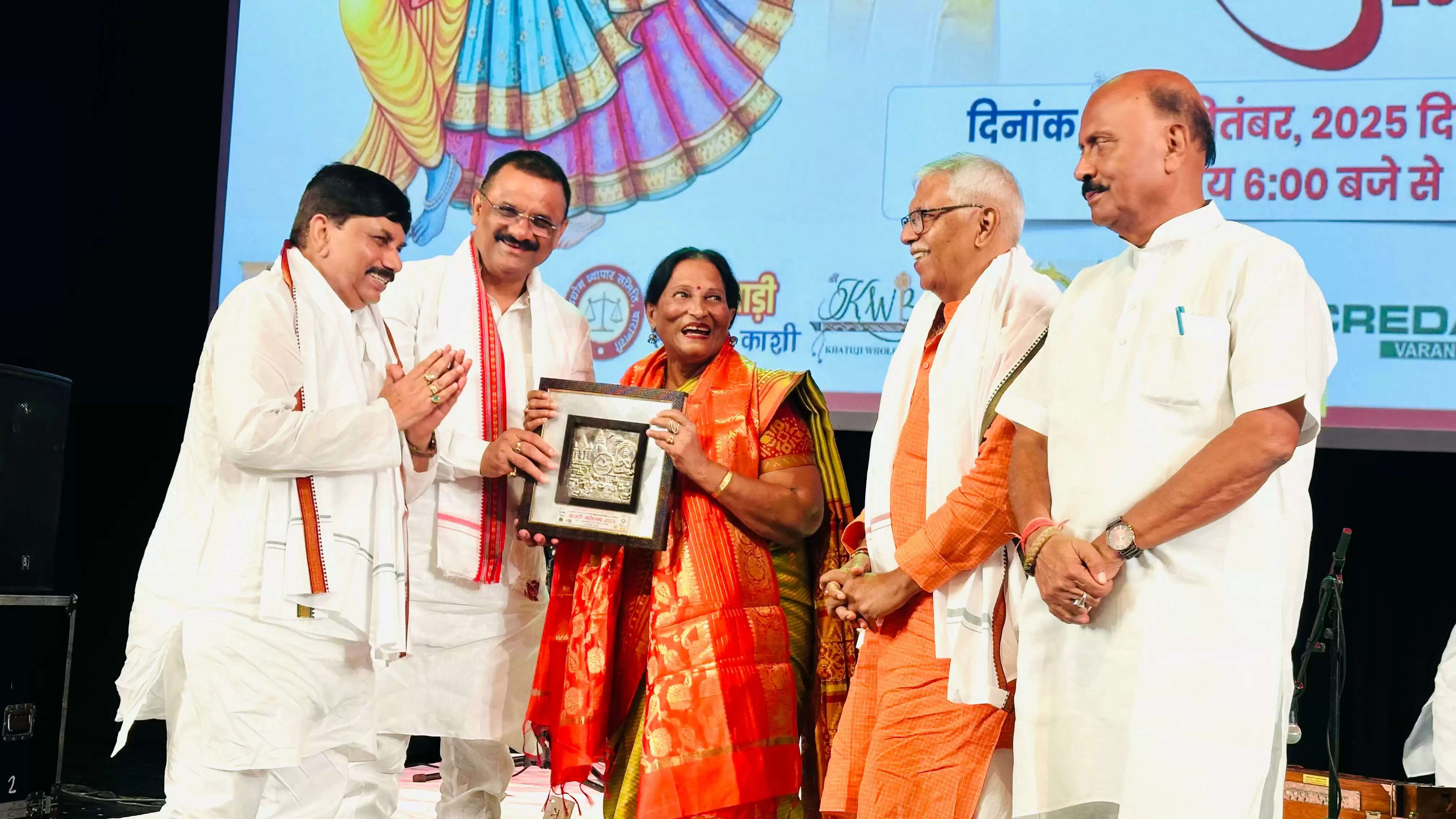 प्रधानमंत्री नरेंद्र मोदी के 75वें जन्मदिन की पूर्व संध्या पर वाराणसी के रुद्राक्ष कन्वेंशन सेंटर में एक भव्य कजरी कार्यक्रम का आयोजन किया गया। इस अवसर पर पद्मश्री गायिका श्रीमती उर्मिला श्रीवास्तव ने अपनी मधुर आवाज में कजरी प्रस्तुत कर दर्शकों को मंत्रमुग्ध कर दिया। कार्यक्रम का आयोजन महापौर श्री अशोक कुमार तिवारी द्वारा किया गया, जिसमें शहर के गणमान्य व्यक्ति, जनप्रतिनिधि और वरिष्ठ प्रशासनिक अधिकारी शामिल हुए।