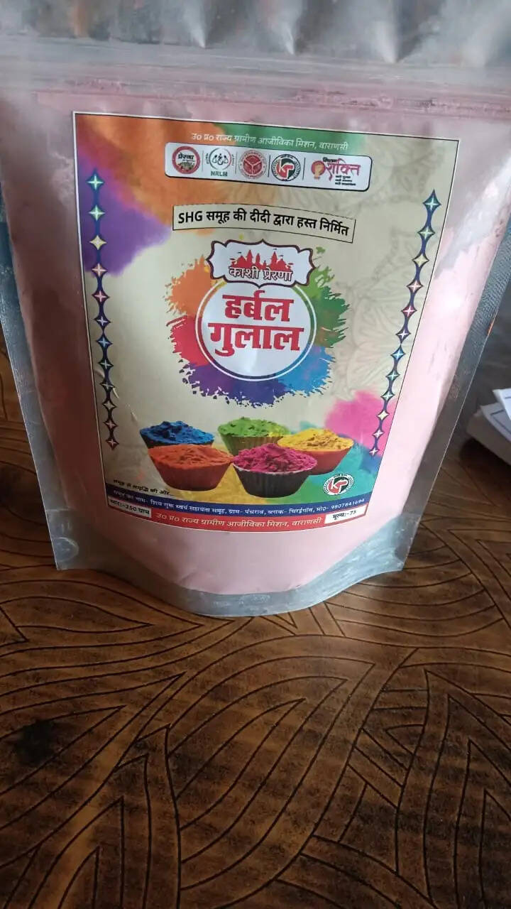 योगी सरकार राष्ट्रीय ग्रामीण आजीविका मिशन से ग्रामीण महिलाओं के जीवन में रंग भर रही है। होली के पर्व पर एक बार फिर काशी में हर्बल गुलाल की मांग तेजी से बढ़ी है। रासायनिक रंगों से होने वाले दुष्प्रभावों को देखते हुए लोग प्राकृतिक और सुरक्षित विकल्प अपना रहे हैं। इसका लाभ ग्रामीण क्षेत्रों की स्वयं सहायता समूह की महिलाओं को सीधे मिल रहा है। वे अपने हुनर और परिश्रम से न सिर्फ शुद्ध हर्बल गुलाल तैयार कर रहीं हैं, बल्कि स्वावलंबन के कैनवास पर हर्बल गुलाल के रंगों के माध्यम से आत्मनिर्भर और आत्मविश्वास की नई तस्वीर उकेर रही है।