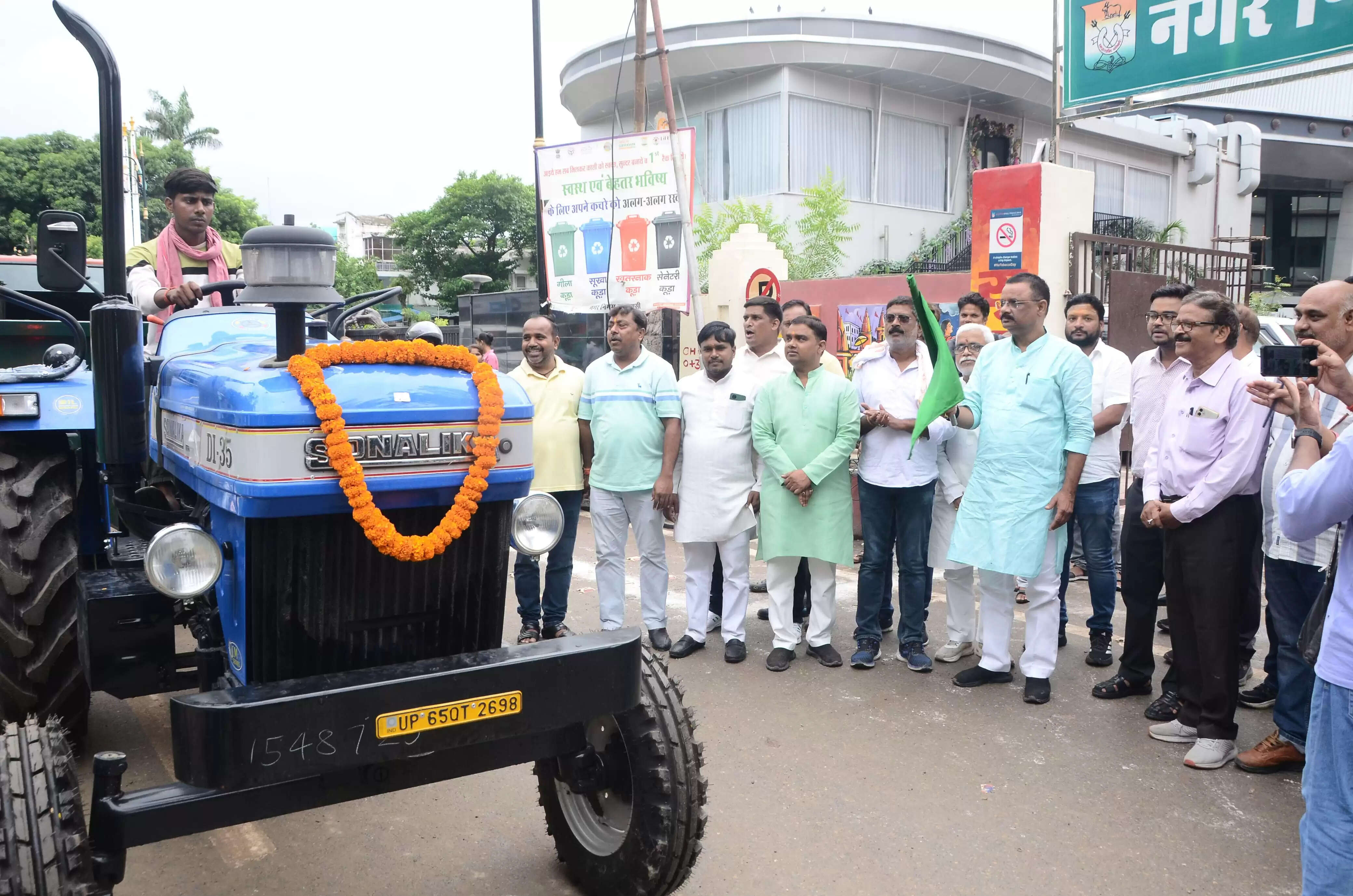 वाराणसी नगर निगम ने शहर की सफाई व्यवस्था को और अधिक सुदृढ़ करने की दिशा में एक और महत्वपूर्ण कदम उठाया है। आज दिनांक 16 जुलाई को माननीय महापौर श्री अशोक कुमार तिवारी ने 7 नई ट्रैक्टर-ट्रॉली और 36 डीपी कंटेनर को हरी झंडी दिखाकर शहरवासियों को समर्पित किया। इस अवसर पर महापौर ने कहा कि ये नए संसाधन कचरा संग्रहण और परिवहन की प्रक्रिया को और तेज करेंगे, जिससे शहर के हर कोने तक सफाई सेवाएं प्रभावी ढंग से पहुंच सकेंगी।